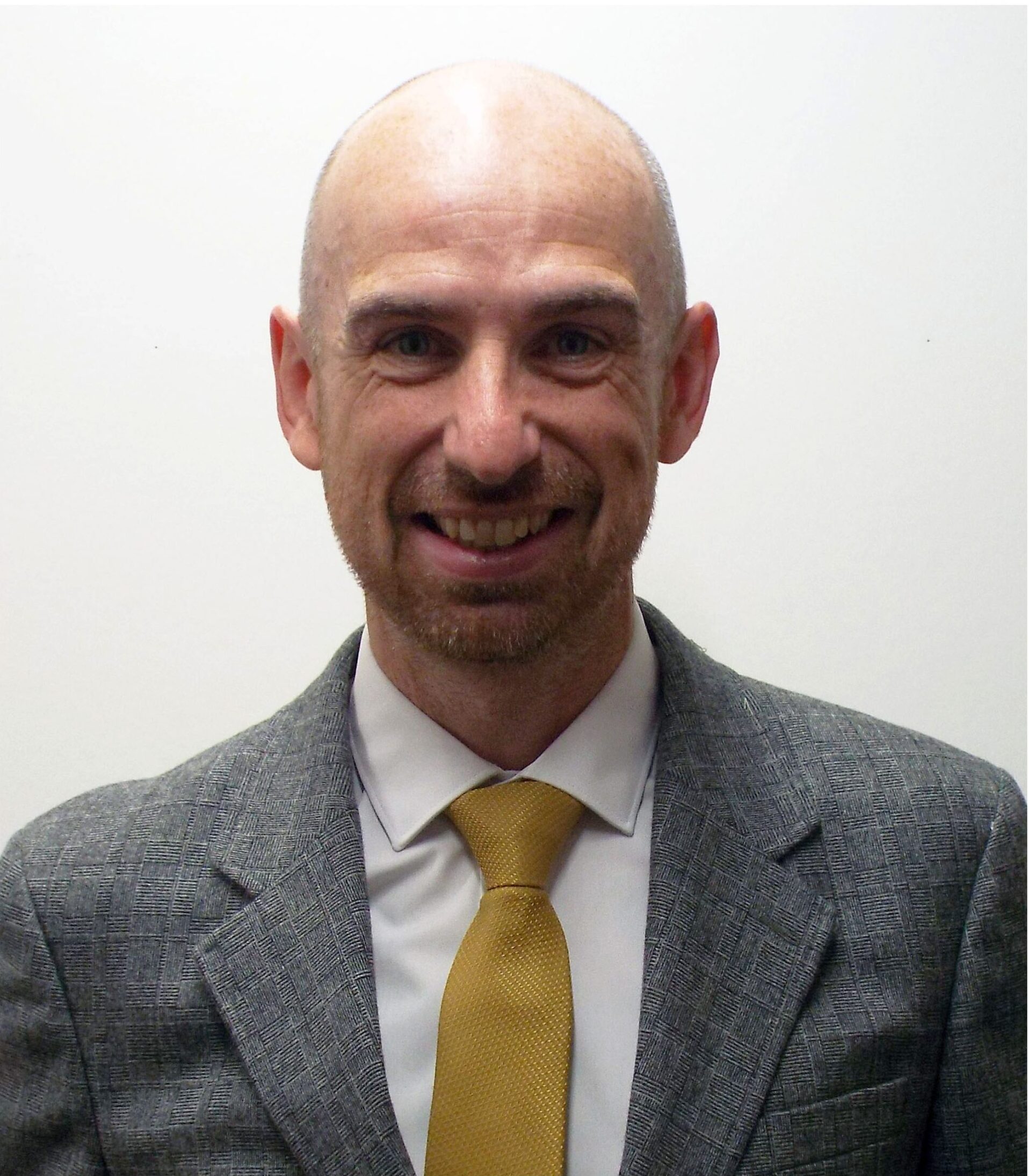 Portrait of a smiling man in a suit Kevi Foundation