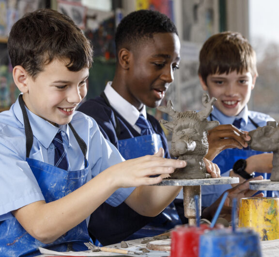 Students engaged in pottery class at Kevi Foundation, shaping clay sculptures with guidance and creativity.