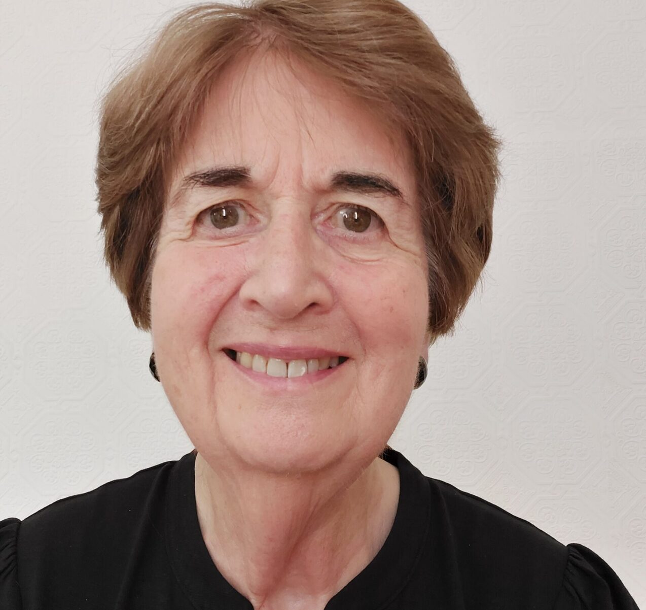 Portrait of a smiling woman with short brown hair in professional attire.