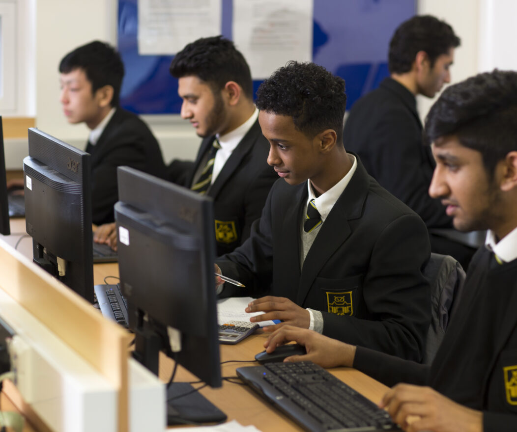 Kevi Foundation students in school uniforms work diligently on computers in a well-equipped classroom.