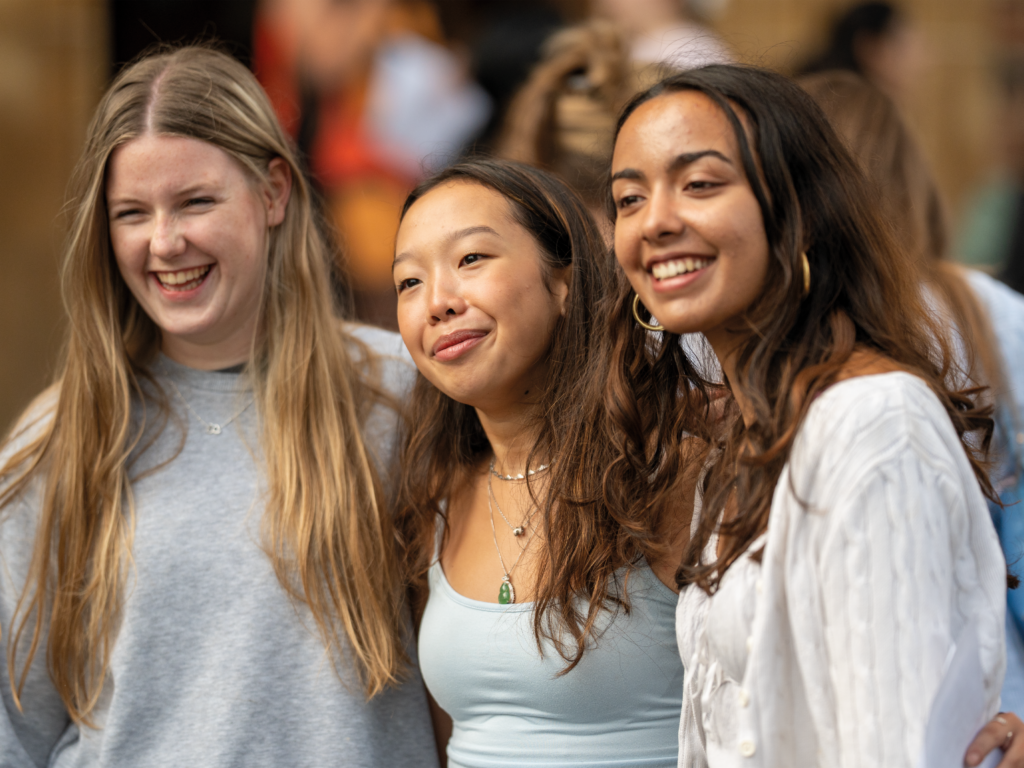 Diverse group of smiling students posing together, showcasing inclusivity and friendship on campus.